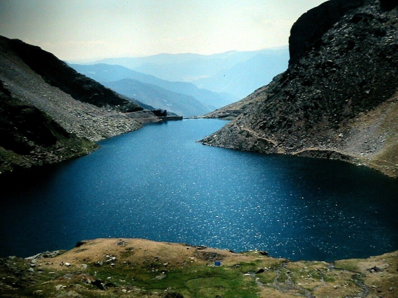 A deep blue lake surrounded by rocky mountains.