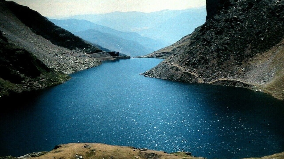 A deep blue lake surrounded by rocky mountains.