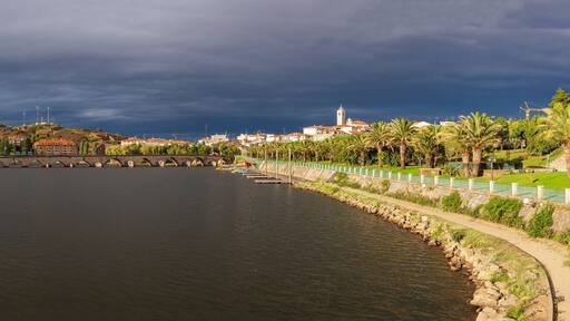 Urban landscape of the city of Mirandela in the north of Portugal. Panoramic view of the banks of the river Tua with the traditional Roman bridge and the historic center with its church tower.