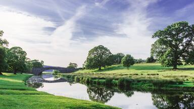 Bridge in Dallam Park, Milnthorpe, Cumbria passing over the river Bela on a sunny evening