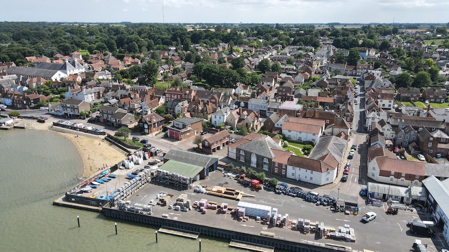 A coastal town with a marina, residential buildings, and a beach.
