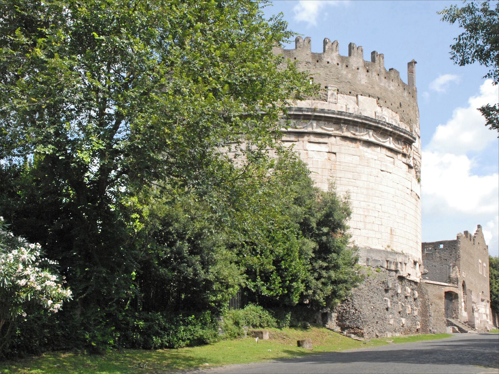 La tombe de Caecilia Metella sur la Via Appia Antica La Via Appia Antica a été construite en 312 av J.-C., elle reliait Rome à Capoue. Par la suite, elle fut prolongée jusqu'à Brindisi. Dans Rome, elle débutait près des thermes de Caracalla. La largeur de la chaussée était de 4,1 m avec un pavement en dalles de basalte. Dans l'Antiquité, les morts étaient ensevelis hors des murs de la Cité ainsi les tombes étaient en bordure des routes. Sur les 20 premiers kilomètres de la Via Appia, on trouvait les tombeaux de familles patriciennes ainsi que plus tard les catacombes chrétiennes. Parmi ceux-ci, la tombe de Caecilia Metella (élevée entre 30 et 20 av. J.-C.) est célèbre en raison de son état de conservation et de sa forme cylindrique. Celle-ci a été transformée en forteresse au Moyen-Âge comme le montrent les créneaux qui subsistent. En 1988, le parc régional de la Via Appia a été créé afin de protéger cette zone archéologique majeure.