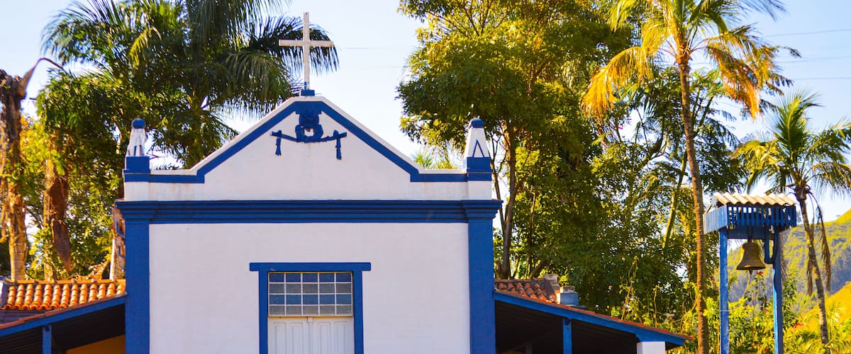 A white and blue church with a bell tower and steps leading up to the entrance.