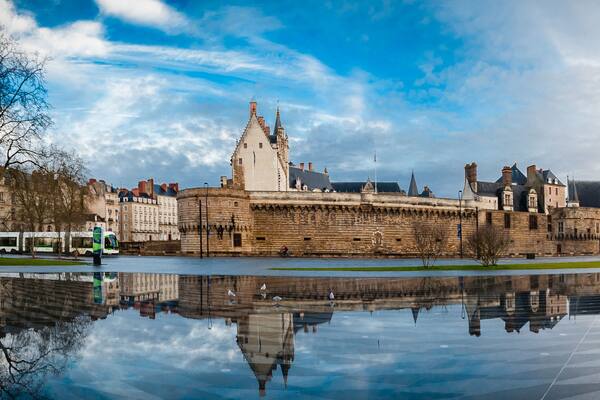 Un château historique, doté d’un fossé et dont l’image se reflète clairement dans l’eau.