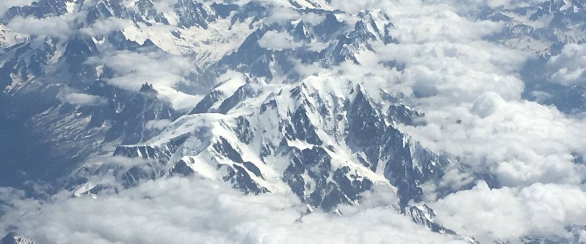 Snow-covered mountain peaks with clouds below.