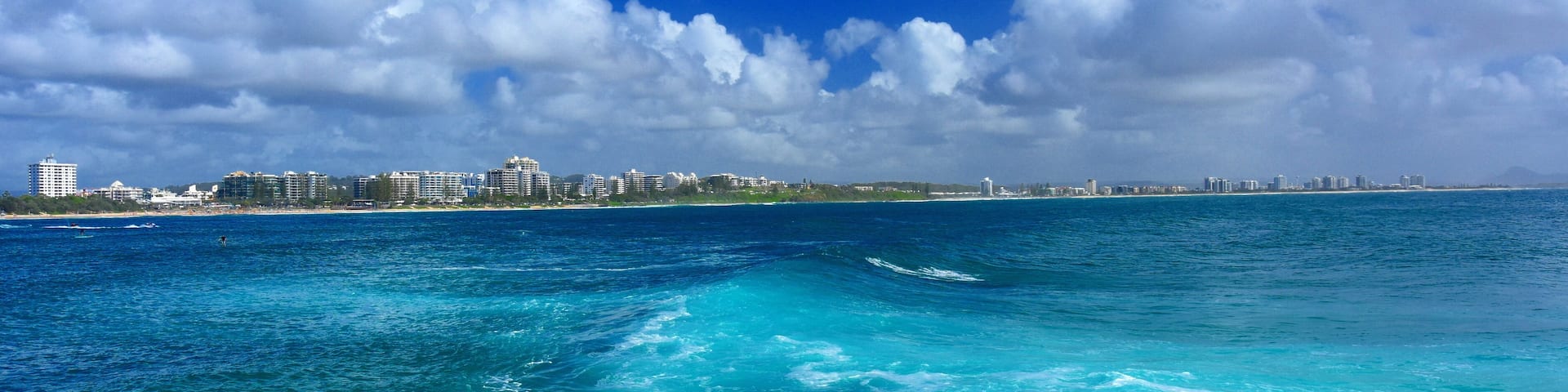 Beautiful weather at Buddina Beach along Pacific Boulevard (Sunshine Coast, Queensland, Australia). Big waves. Mooloolaba in the background.