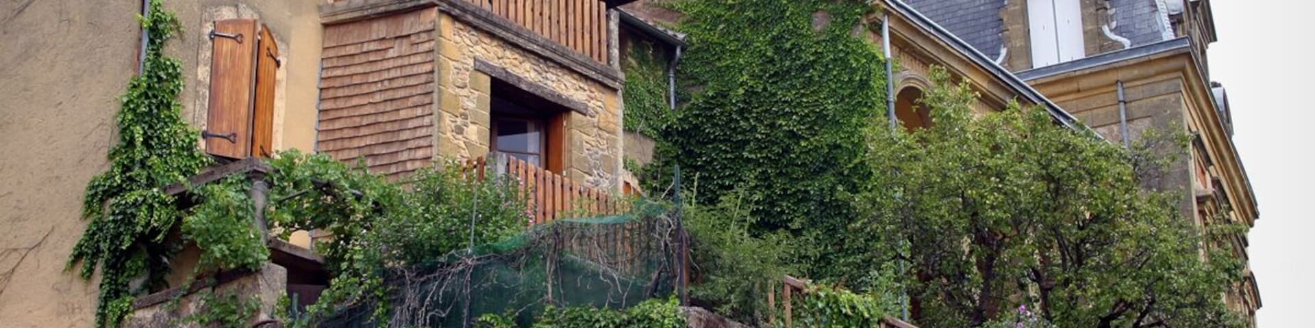 A building with a wooden balcony and ivy-covered walls.