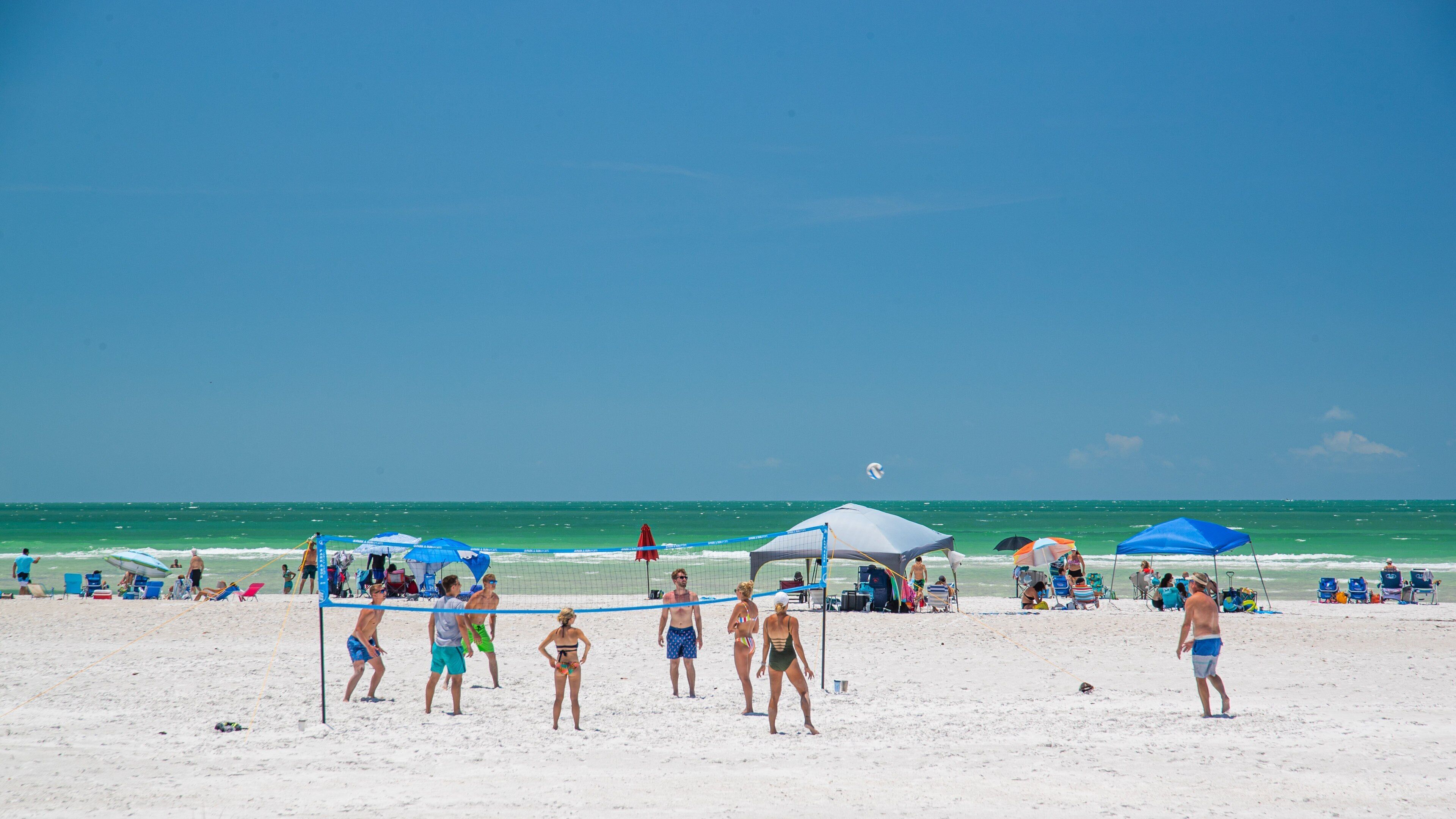 Lido Beach showing a sandy beach and general coastal views as well as a small group of people