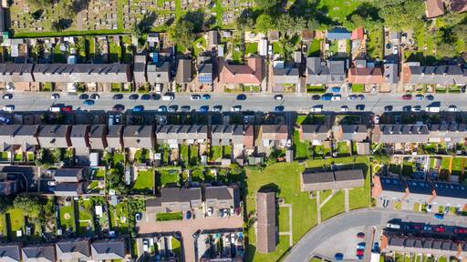 A residential area with houses, a road, and a cemetery.