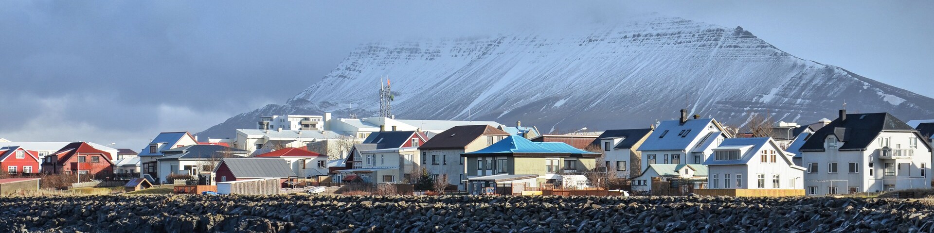 Akranes, Iceland, February 28, 2012: Colorful houses next to the beach with mountains partially obscured by clouds in the background
