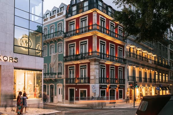 Eine Straße mit einem Michael Kors Geschäft und einem Gebäude von Maria João Batista.