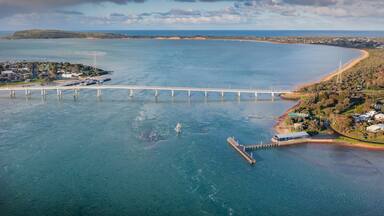 Aerial view of a narrow bridge linking the mainland to a coastal island
