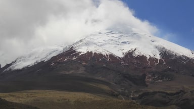 A snow-capped mountain with a clear sky and clouds.