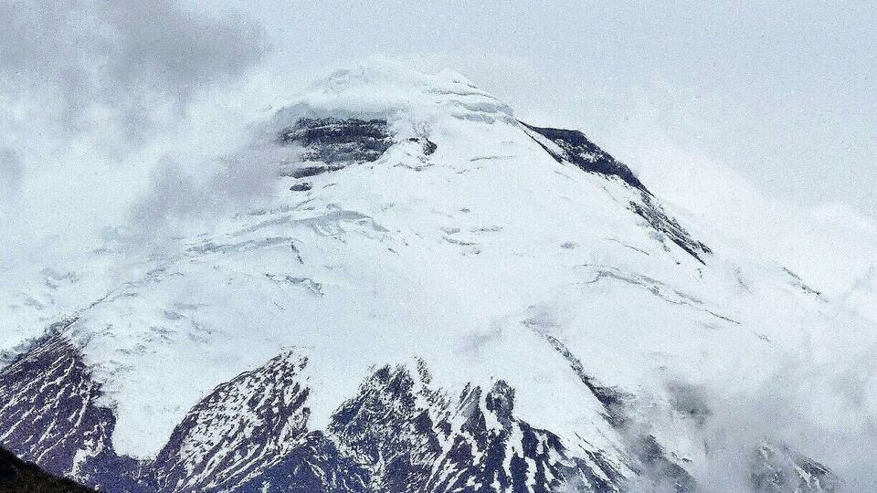 A snow-covered mountain with sharp peaks and a rugged terrain.