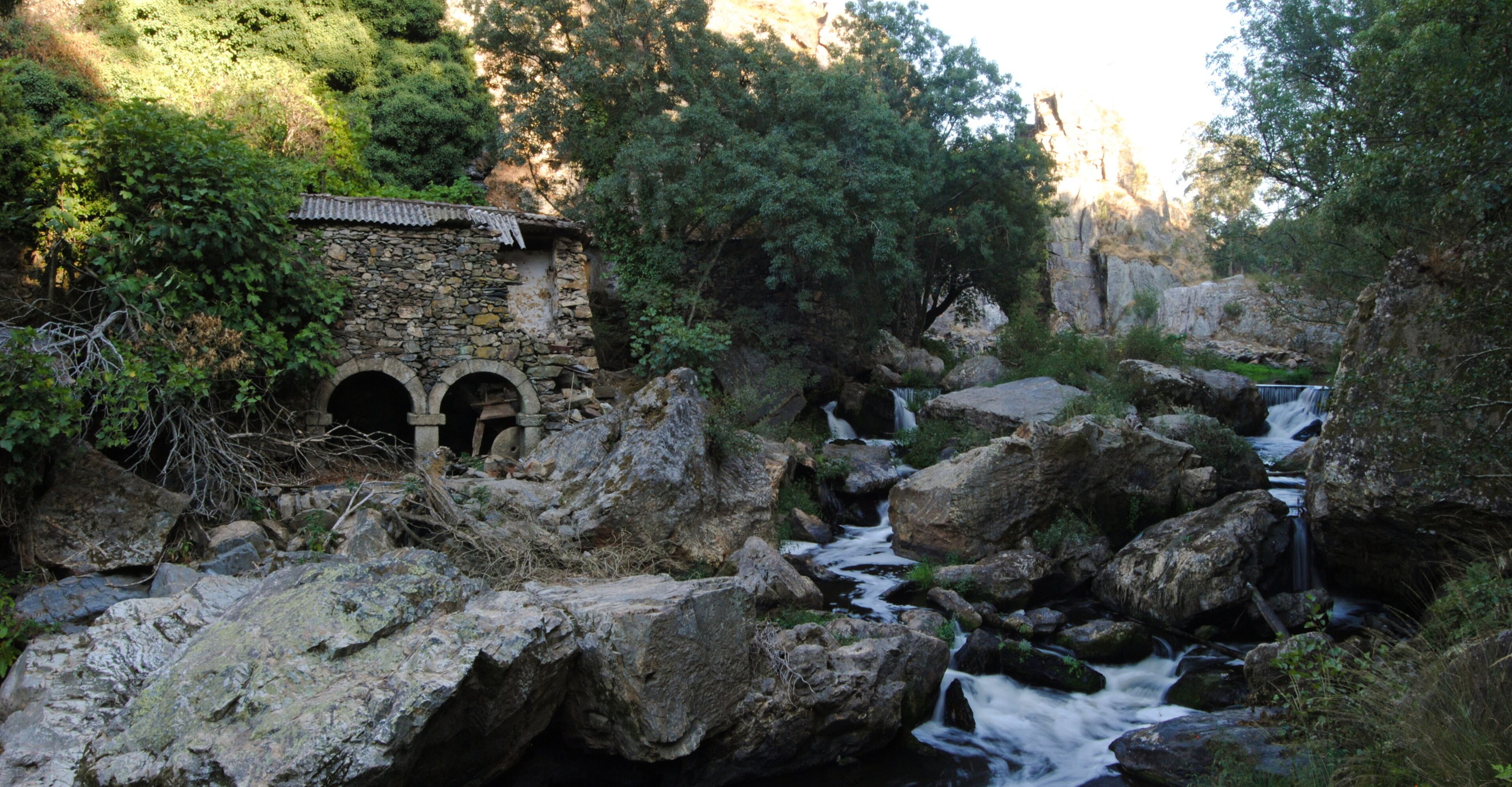 Moinho em ruinas - construido em pedra, rio a correr com velocidade por entre as pedras - abandonado
