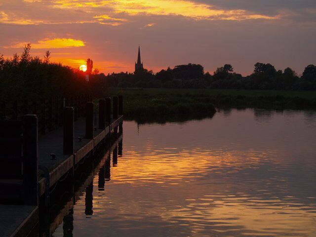 Sunset over Lechlade in Gloucestershire, with the spire of St Lawrence's parish church on the skyline, seen from St John's Lock on the River Thames