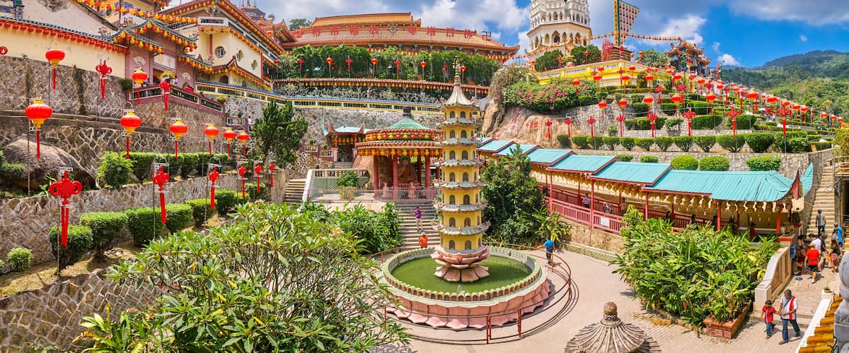 A traditional Chinese temple complex with pagodas, ornate architecture, and lush greenery.