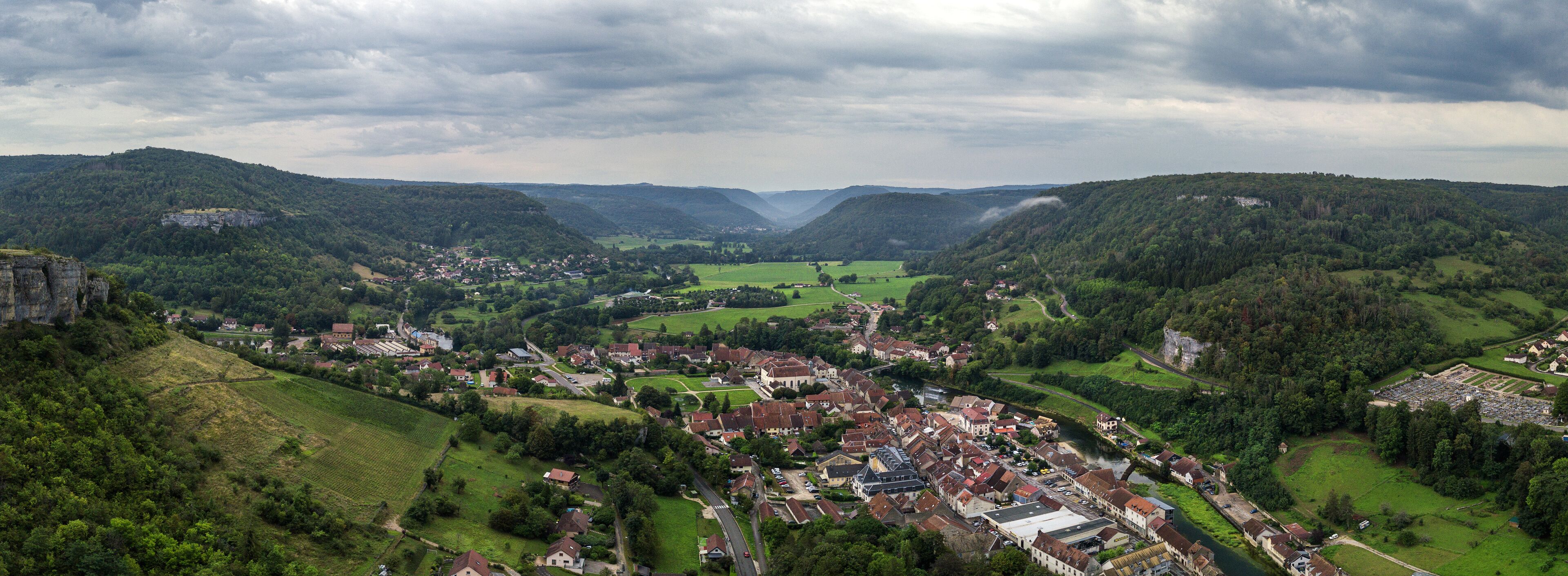 A valley with a town surrounded by hills and a river.
