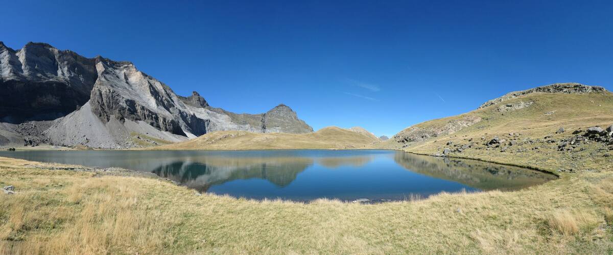 A mountain landscape with a calm lake reflecting the peaks.