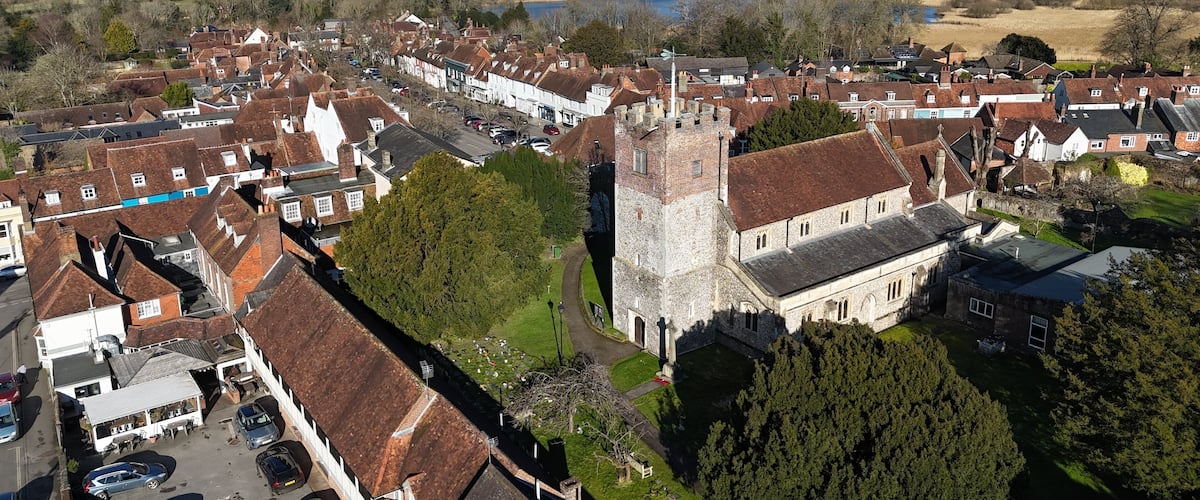 A town with historic buildings, a church, and a river in the background.