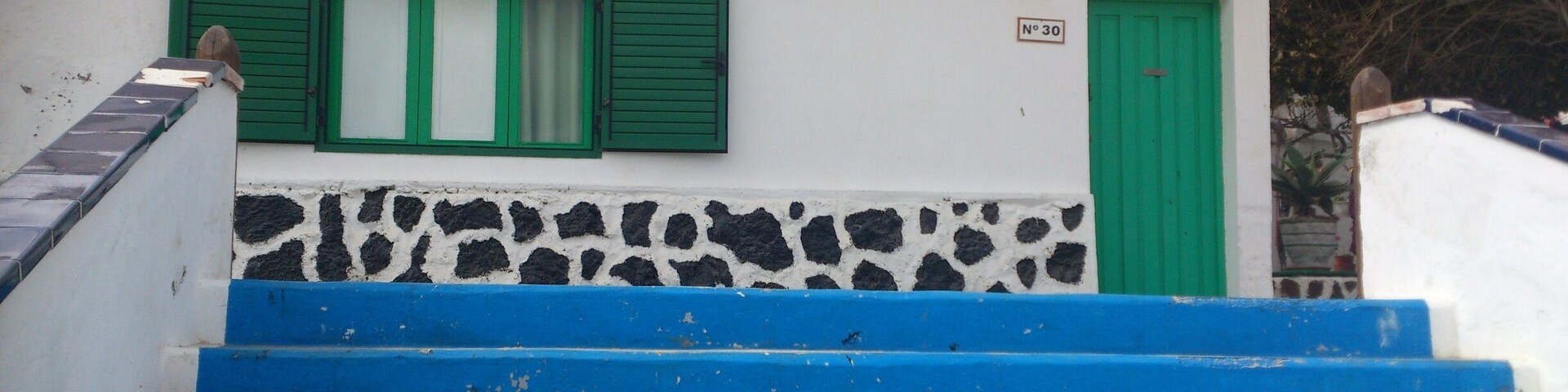 One of the oldest houses in Corralejo, I can't remember if it is the actual oldest or just next door to the oldest, but it is an original fisherman's cottage in typical Canarian style with an interior patio - the patio is between the main house and the bedrooms instead of at the front or rear of the house.
And just down those steps ...is the beach, la playa de ninas. Small soft sand beach and calm waters perfect for children.