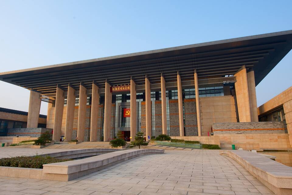 Un edificio moderno con techo plano y columnas verticales.