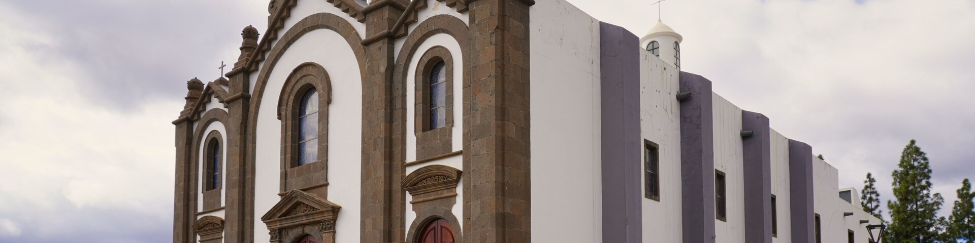 A historic church with a clock tower, arched windows, and a prominent bell.