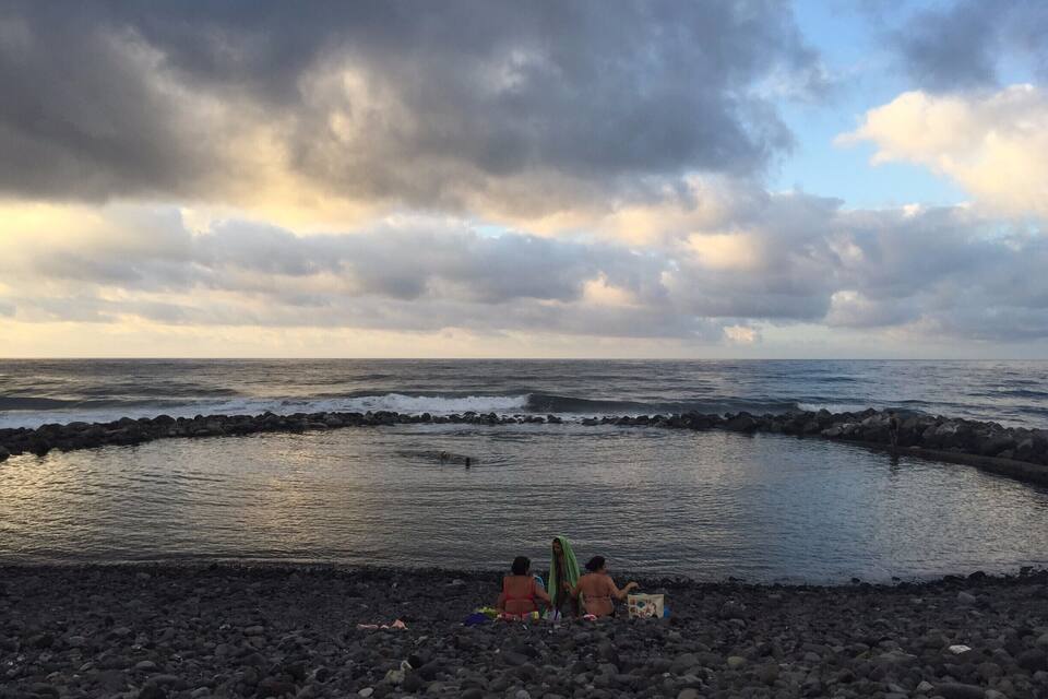 En stenstrand där vågorna slår mot en vågbrytare.