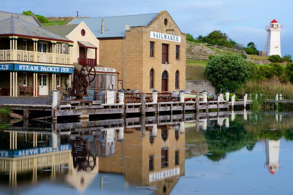 A waterfront with a steam packet inn, a sailmaker building, and a lighthouse.