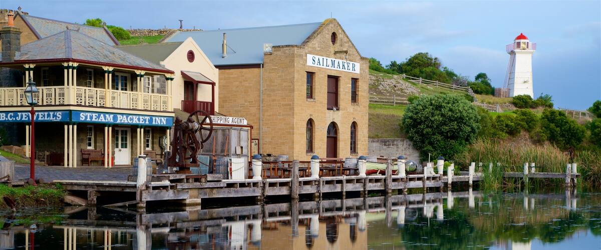 A waterfront with a steam packet inn, a sailmaker building, and a lighthouse.