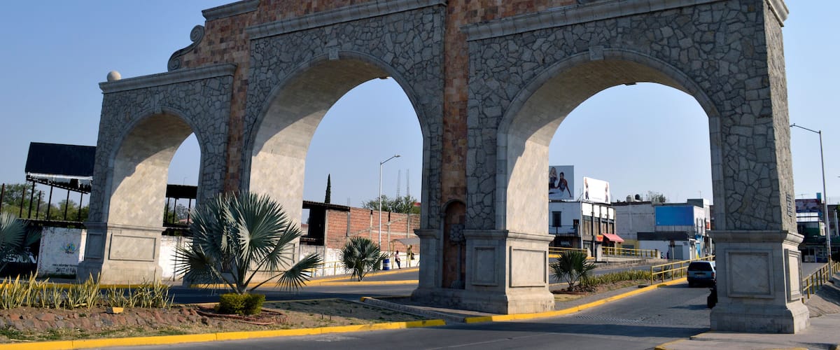 A stone archway with a dome and eagle statue.