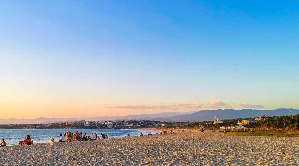 Colorful golden sunset people wave and beach Puerto Escondido Mexico.