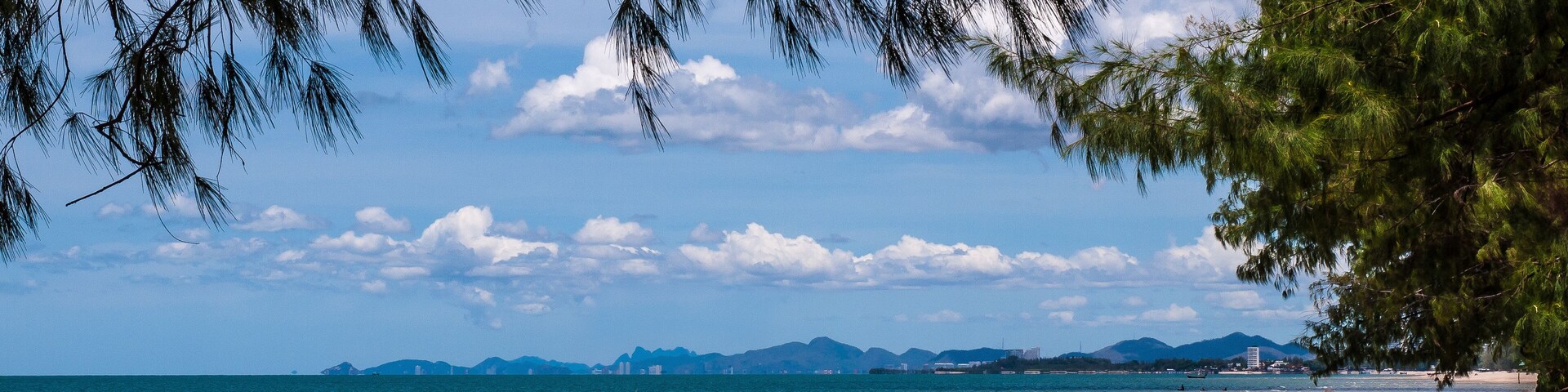 Beautiful Cha-am beach with blue sky and pine trees.