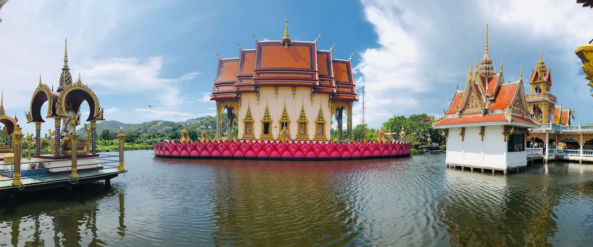 A temple with a lotus-shaped platform, golden spires, and a red roof.