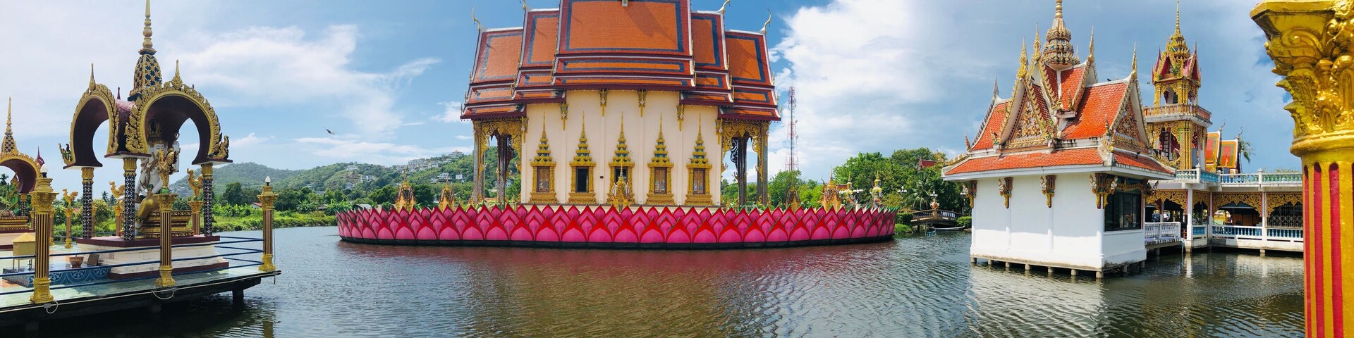 A temple with a lotus-shaped platform, golden spires, and a red roof.