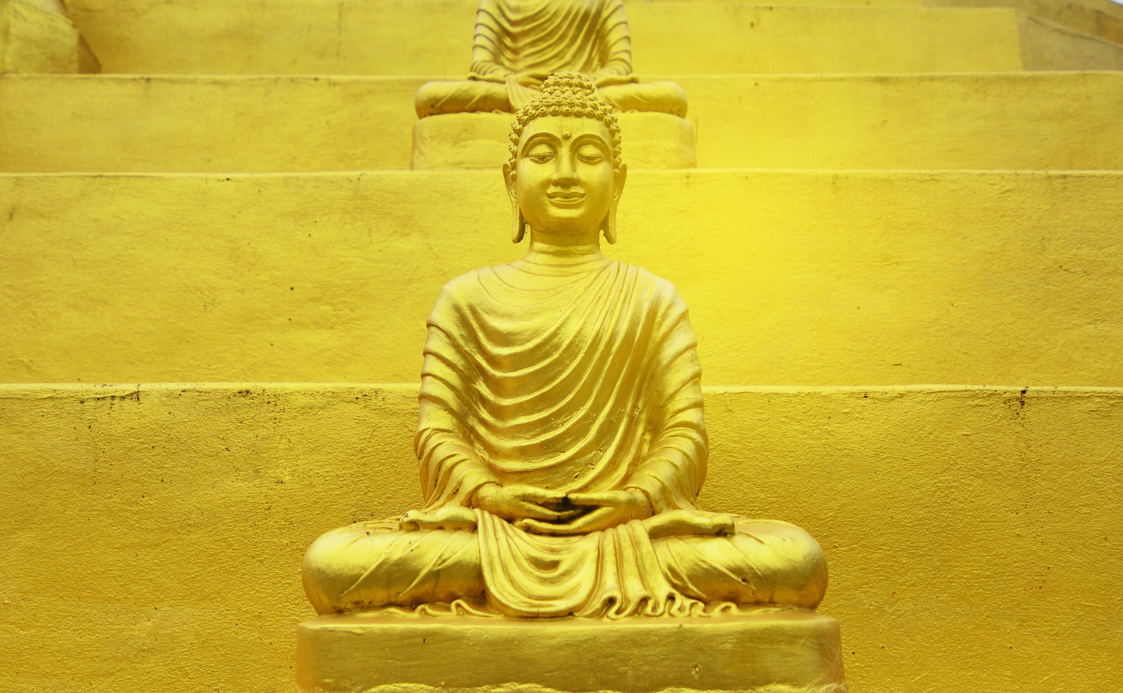 Buddha statue golden of Wat Phra That Chulamanee Sri Siam, Baan kormanae, Tambon Tha Song Yang Tak Province THAILAND with flog cloud, mountain and green trees background