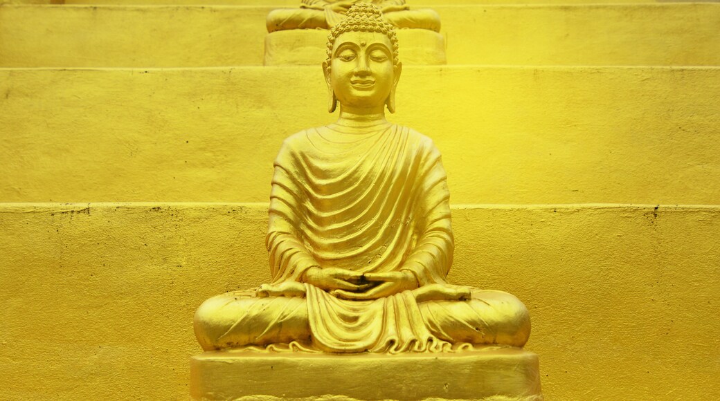 Buddha statue golden of Wat Phra That Chulamanee Sri Siam, Baan kormanae, Tambon Tha Song Yang Tak Province THAILAND with flog cloud, mountain and green trees background
