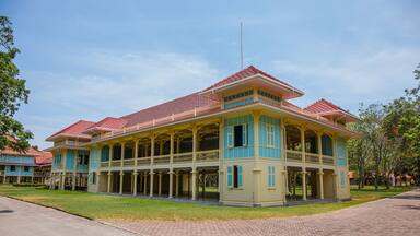 Um edifício em estilo colonial com telhado de telhas vermelhas e detalhes em azul e amarelo.