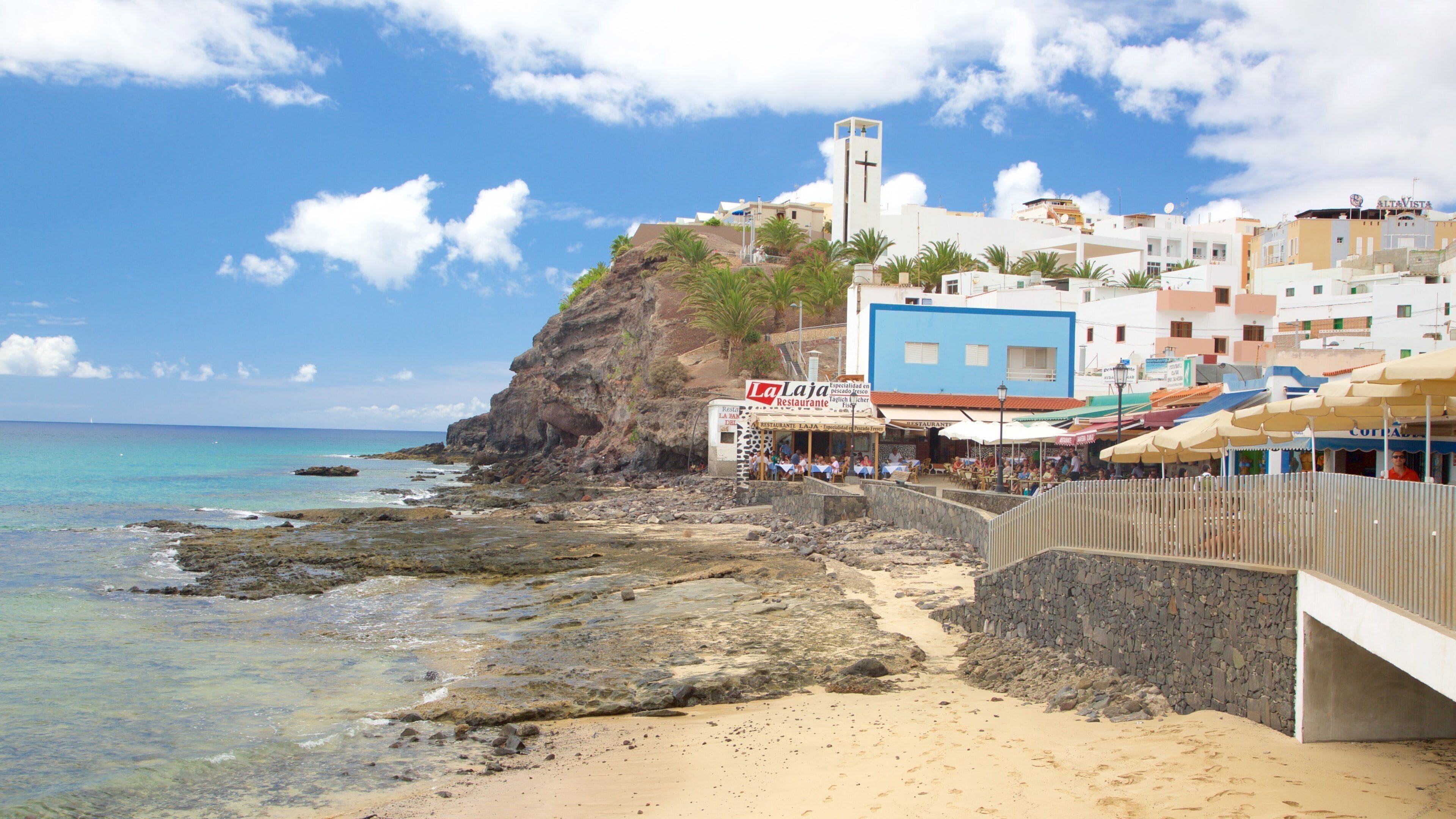Morro Jable showing a sandy beach, rocky coastline and a coastal town