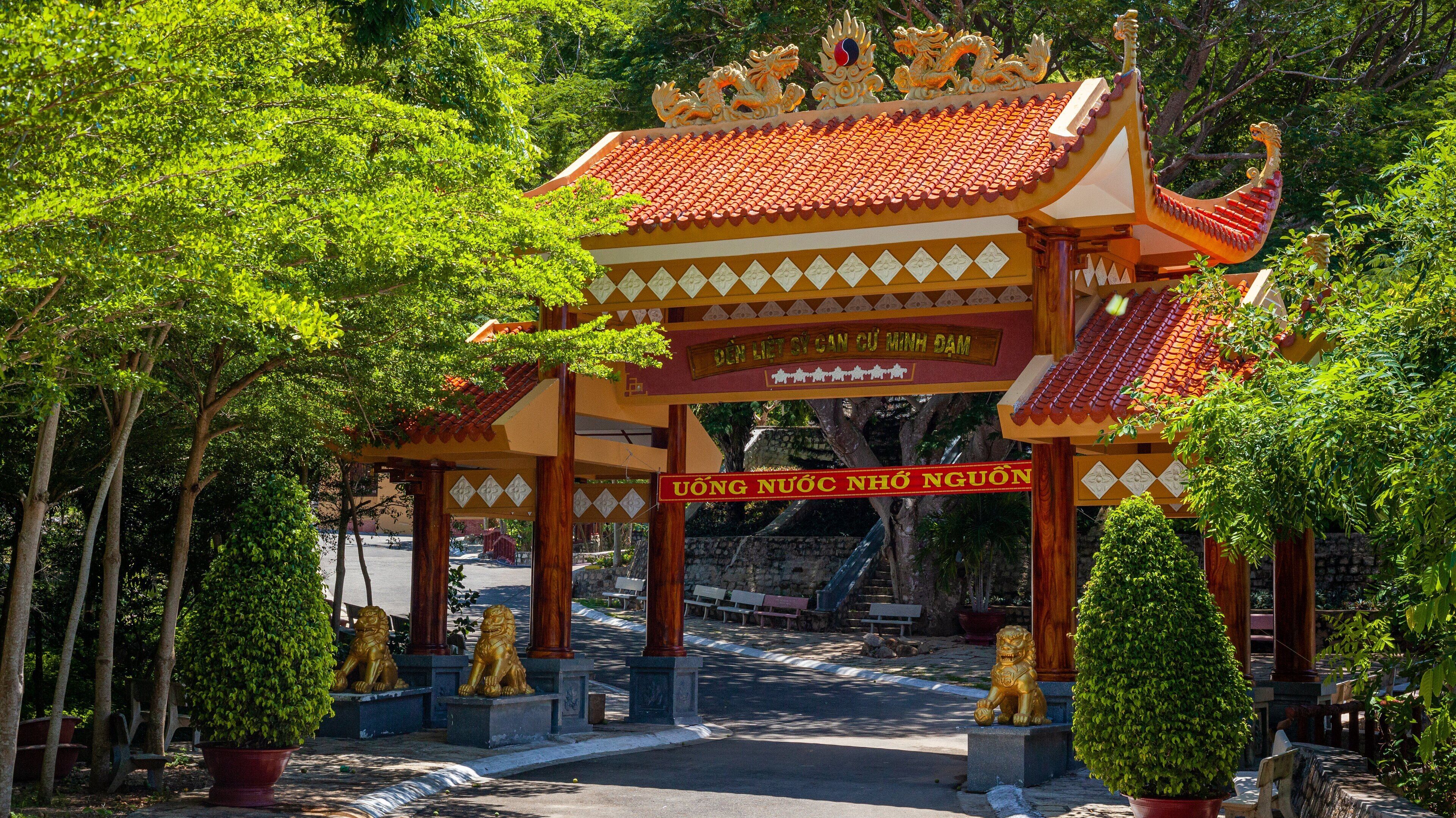 A traditional Vietnamese gate with ornate decorations and golden statues.