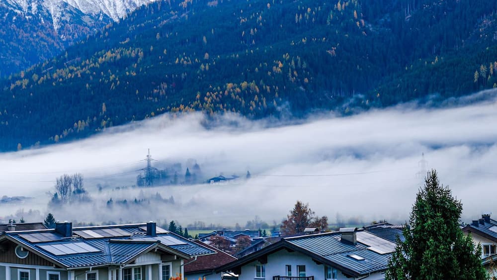 A mountain village with houses, a church, and a church steeple.
