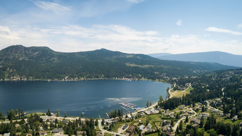 A lake surrounded by mountains, a marina, and a residential area.