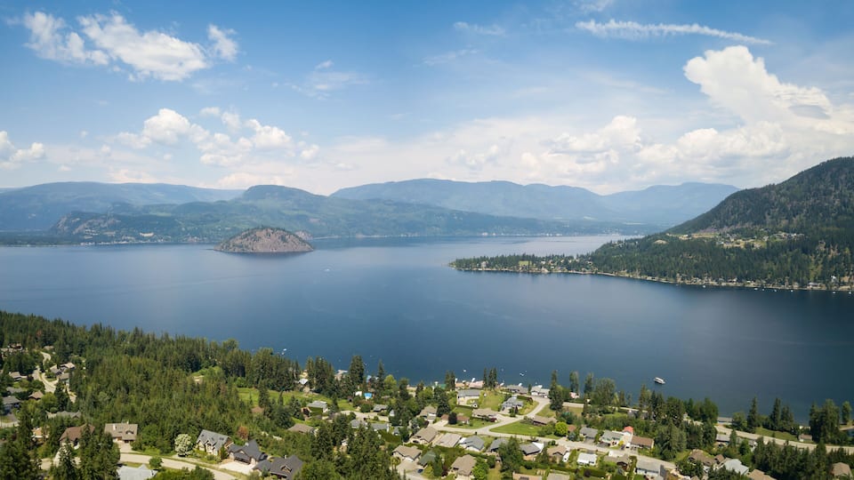 A lake surrounded by mountains and a residential area.
