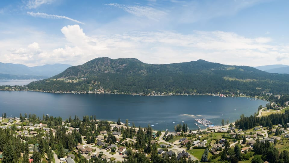 A lake surrounded by mountains and a residential area.