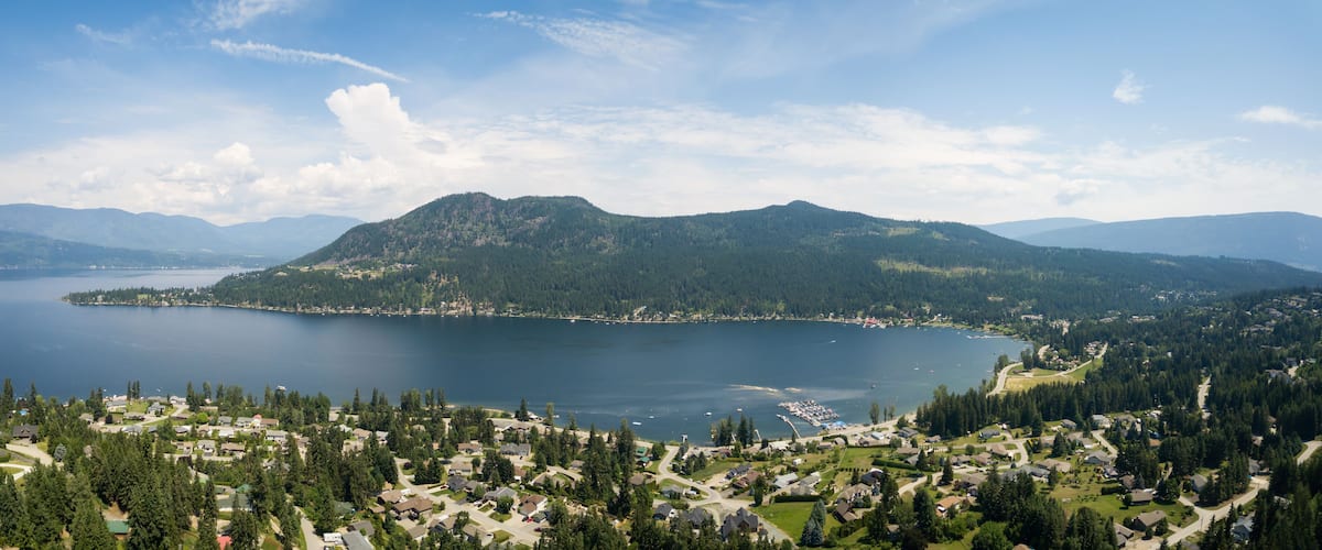 A lake surrounded by mountains and a residential area.