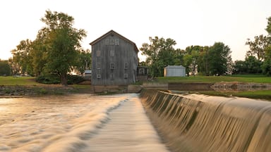 Un molino de madera con un canal de agua al frente.