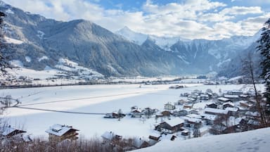 A snow-covered village nestled in a valley with mountains in the background.