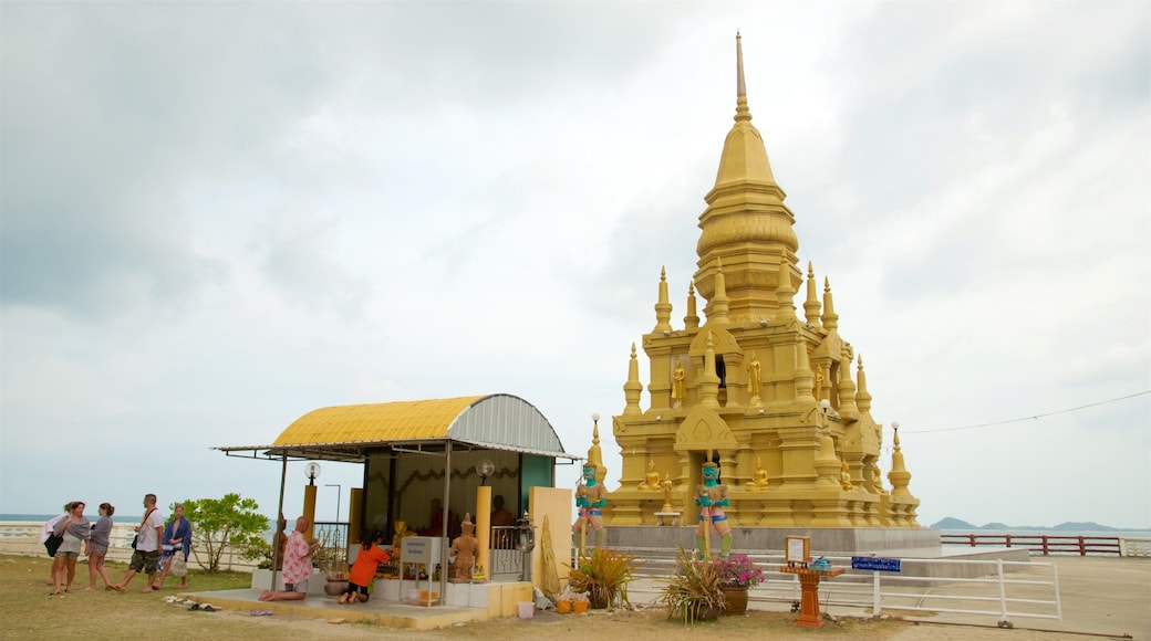 Laem Sor Chedi featuring a temple or place of worship as well as a small group of people