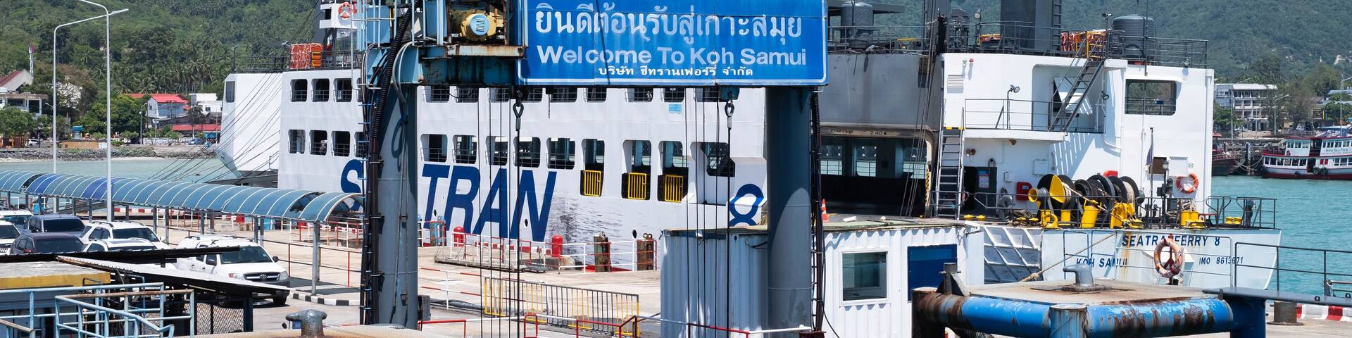 A ferry dock with a sign reading "Welcome To Koh Samui" and a ferry named "SEATRA CERRY 8".