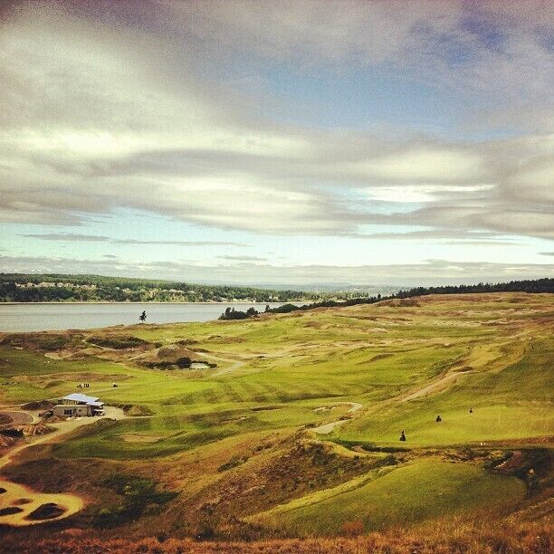 A golf course with a lake and a distant shoreline.